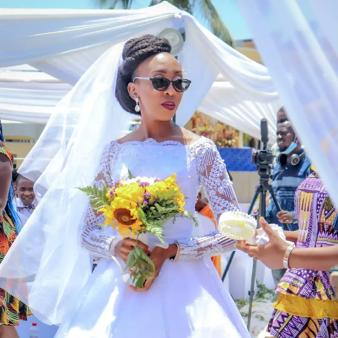 Smiling bride with a sunflower bouquet at an outdoor wedding ceremony in Kenya