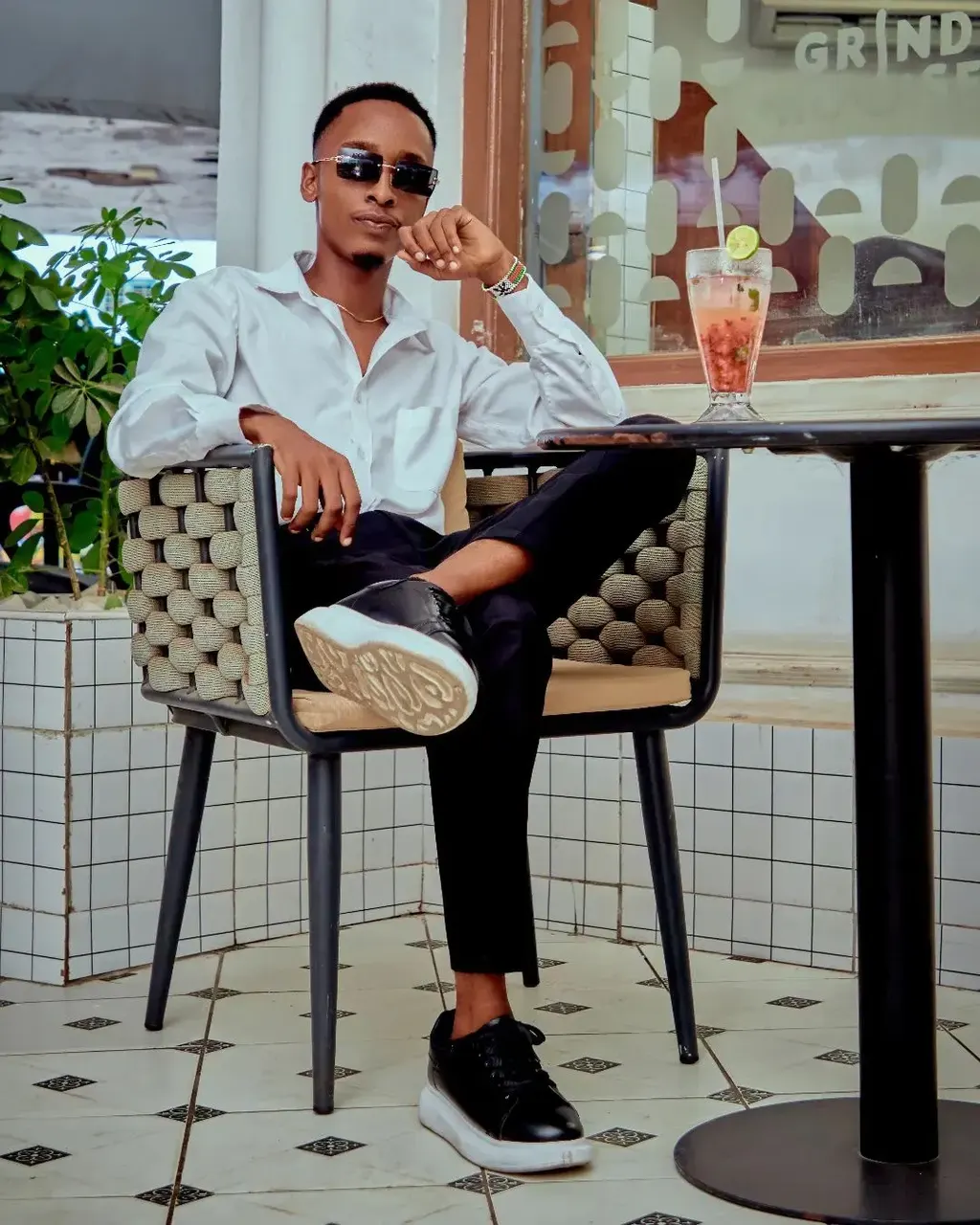 Lifestyle portrait of a man in a white shirt seated at a café