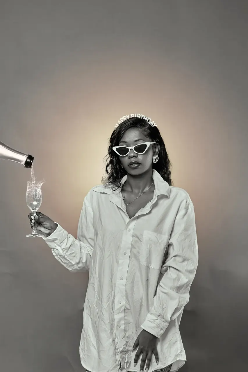 Black and white studio photoshoot with champagne pour and sunglasses