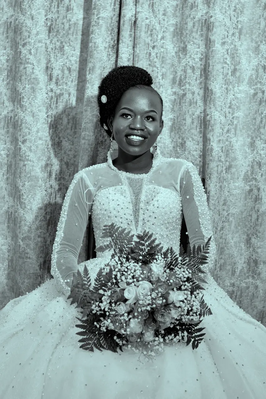 Black and white portrait of a bride in a lace gown holding her bouquet