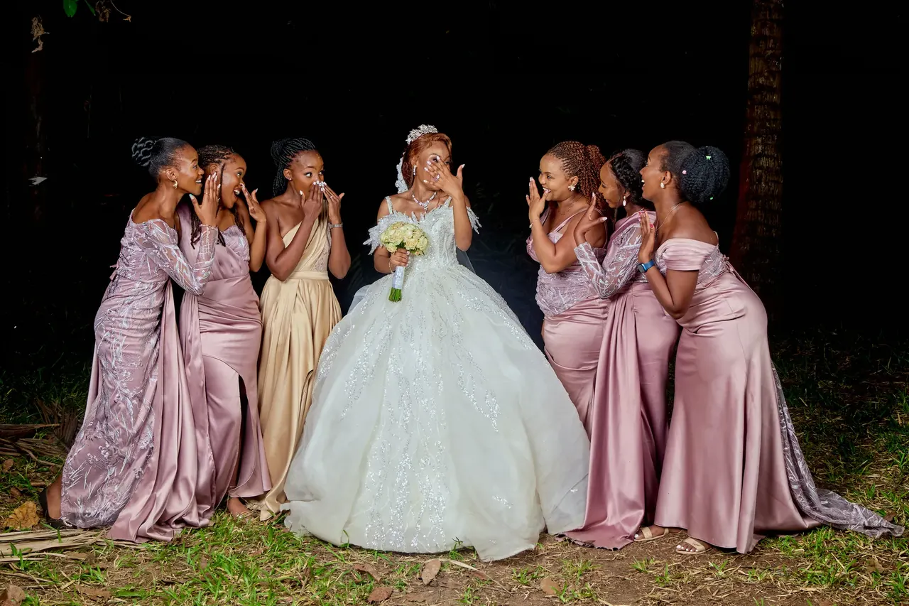Bridal party portrait with bride in white and bridesmaids in pink satin dresses