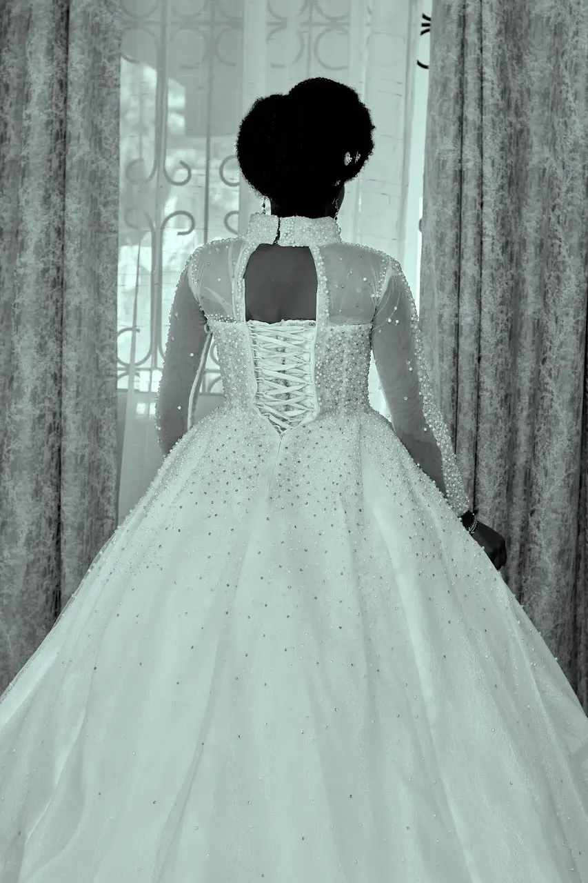 Corset back detail of a wedding dress by a window, black and white